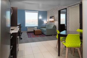 ein Wohnzimmer mit einem Tisch und gelben Stühlen in der Unterkunft Home2 Suites By Hilton Page Lake Powell in Page