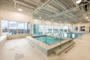 a large indoor pool in a building with windows at Hilton Niagara Falls/ Fallsview Hotel and Suites in Niagara Falls