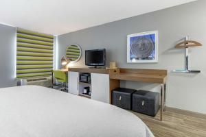 ブルックヘイブンにあるHampton Inn Brookhavenのベッド、デスク、テレビが備わるホテルルームです。