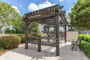 una pérgola de madera con un banco en un parque en Hampton Inn Brookhaven, en Brookhaven