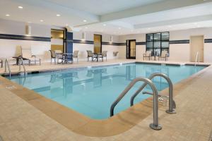 a pool in a hotel with tables and chairs at Hampton Inn & Suites Aberdeen/APG South in Edgewood