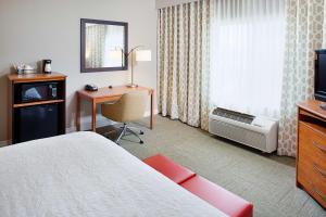 a hotel room with a bed and a desk and a television at Hampton Inn & Suites Lancaster in Lancaster