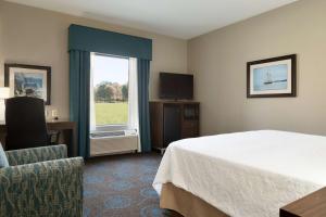 a hotel room with a bed and a window at Hampton Inn & Suites Aberdeen/APG South in Edgewood