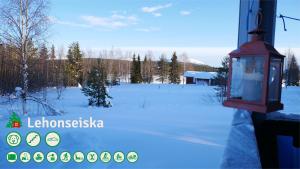 een uitzicht op een met sneeuw bedekt veld met een gebouw bij Talo Ylläs in Äkäslompolo