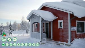 een klein rood huis met sneeuw op het dak bij Talo Ylläs in Äkäslompolo
