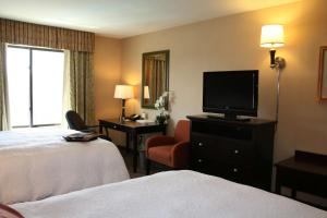 a hotel room with a bed and a flat screen tv at Hampton Inn Las Vegas/North Speedway in Las Vegas