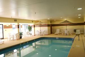 uma piscina com cadeiras, mesas e guarda-sóis em Hampton Inn Marion em Marion