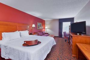 a hotel room with a bed and a flat screen tv at Hampton Inn Marion in Marion