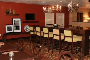 a dining room with a bar with yellow chairs at Hampton Inn Salt Lake City/Murray in Murray