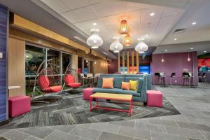 vestíbulo con sofá azul y sillas coloridas en Home2 Suites By Hilton Wichita Falls, Tx en Wichita Falls