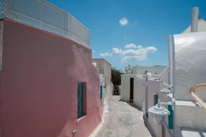 a narrow alley with white buildings and a fence at Marla Luxury Residences in Megalochori