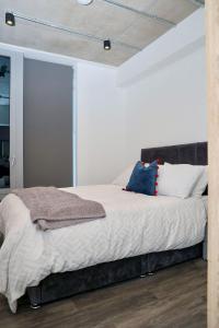1 dormitorio con 1 cama con sábanas y almohadas blancas en Unique comfortable Apartment, en Abbey Wood