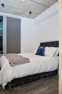 a bedroom with a bed with white sheets and pillows at Unique comfortable Apartment in Abbey Wood