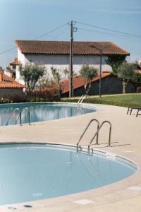 an empty swimming pool with two metal bars in it at Quinta da Corredoura, Hotel Rural in Guimarães