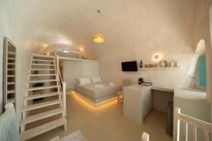 a small room with a staircase and a bed at Marla Luxury Residences in Megalochori
