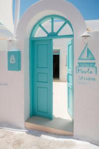una porta blu sul lato di un edificio di Marla Luxury Residences a Megalochori