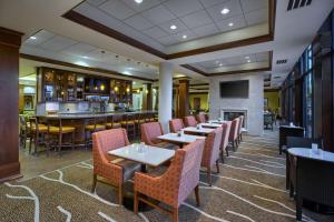 a restaurant with tables and chairs and a bar at Hilton Garden Inn Durham-University Medical Center in Durham