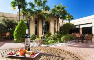 einen Tisch mit einem Teller Essen und einer Flasche Wein in der Unterkunft Hilton New Orleans Airport in Kenner