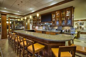 a bar in a restaurant with chairs and a television at Hilton Garden Inn Durham-University Medical Center in Durham