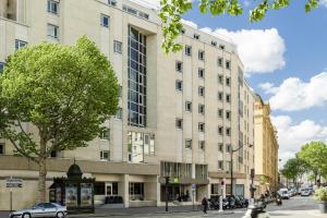 un grand bâtiment dans une rue de la ville avec un arbre dans l'établissement ibis Styles Paris Gare de l'Est Château Landon, à Paris