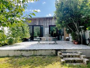 een patio met een tafel en stoelen voor een huis bij Loft House, Pool & Garden in Montreuil