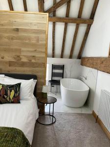 a bedroom with a bed and a bath tub at Grange Farm Barn, Filby in Filby