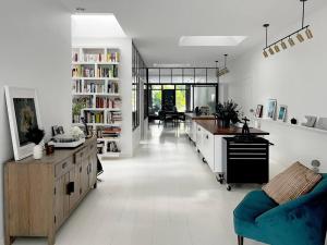 uma ampla sala de estar com pisos brancos e um sofá azul em Loft House, Pool & Garden em Montreuil