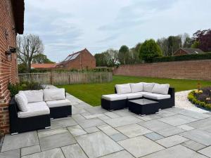 two couches sitting on a patio in a yard at Grange Farm Barn, Filby in Filby