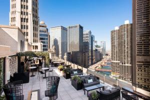 a rooftop patio with tables and chairs in a city at LondonHouse Chicago, Curio Collection by Hilton in Chicago