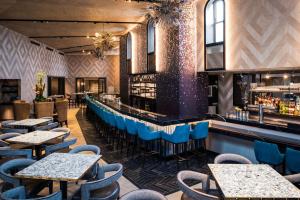 a restaurant with tables and chairs and a bar at LondonHouse Chicago, Curio Collection by Hilton in Chicago