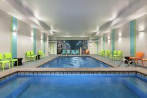 una piscina con sedie e tavoli colorati di Home2 Suites by Hilton Amarillo West Medical Center ad Amarillo