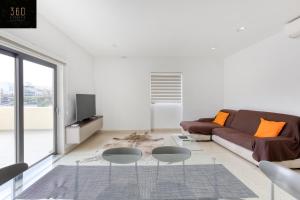 sala de estar con sofá marrón y 2 mesas en Marina VIEW APT SLPs 9 with private terrace & BBQ by 360 Estates, en Taʼ Xbiex