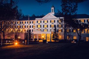 un gran edificio blanco con luces encendidas por la noche en Somerset Hills Hotel, Tapestry Collection by Hilton en Basking Ridge