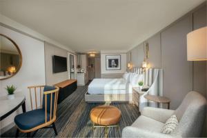 バスキング・リッジにあるSomerset Hills Hotel, Tapestry Collection by Hiltonのベッドとリビングルームが備わるホテルルームです。