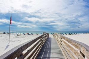 une promenade menant à la plage arborant un drapeau américain dans l'établissement Hilton Garden Inn Orange Beach, à Gulf Shores