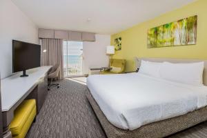 a hotel room with a bed and a television at Hilton Garden Inn Orange Beach in Gulf Shores