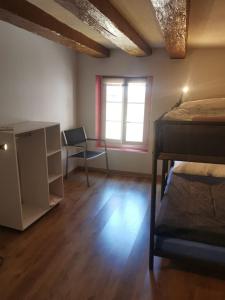 a bedroom with a bed and a desk and a window at La Bergerie in La Neuveville