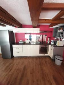 a kitchen with white cabinets and a wooden floor at La Bergerie in La Neuveville