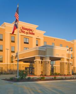 ein Hotel mit amerikanischer Flagge davor in der Unterkunft Hampton Inn & Suites New Braunfels in New Braunfels