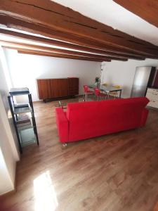 sala de estar con sofá rojo y mesa en La Bergerie, en La Neuveville