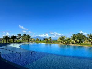 a large swimming pool with blue water and palm trees at Seafront OnCall - private jacuzzi with 4 cozy bedrooms in San Juan