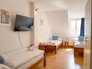 a room with two beds and a flat screen tv at Penzion Portus in Bratislava