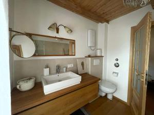 a bathroom with a sink and a toilet at Haus Seerose in Taching am See