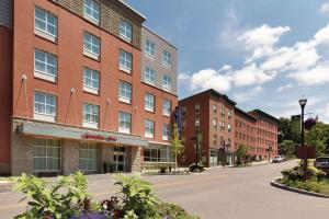 una via cittadina con edifici e una via con fiori di Hampton Inn, St. Albans Vt a Saint Albans