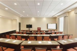 una sala de conferencias con mesas, sillas y una pantalla en Hampton Inn, St. Albans Vt en Saint Albans