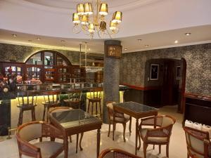 a restaurant with tables and chairs and a bar at Hotel Valles in Mar del Plata