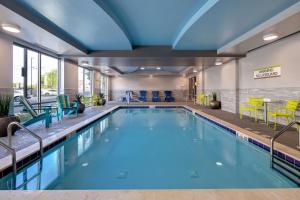 a pool in a hotel room with yellow and blue chairs at Home2 Suites By Hilton Nashville Downtown-Metrocenter in Nashville