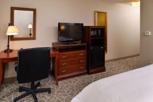 a hotel room with a desk with a television and a bed at Hampton Inn Litchfield in Litchfield