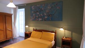 una camera da letto con un letto e un quadro sul muro di Le Moulin du Clapier Le Viennois a Sorges Altre 7 foto