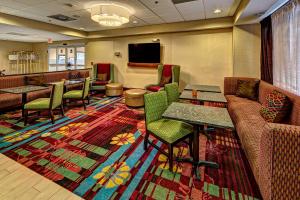 - une salle d'attente avec des chaises, des tables et une télévision dans l'établissement Hampton Inn Manning, à Manning